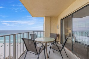 Un balcon avec une porte vitrée, une table ronde et quatre chaises.