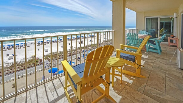 Un balcone con poltrone Adirondack gialle e vista sulla spiaggia.