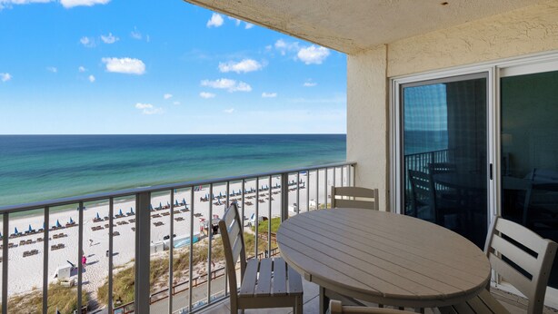 Ein Balkon mit Blick auf Strand und Meer.