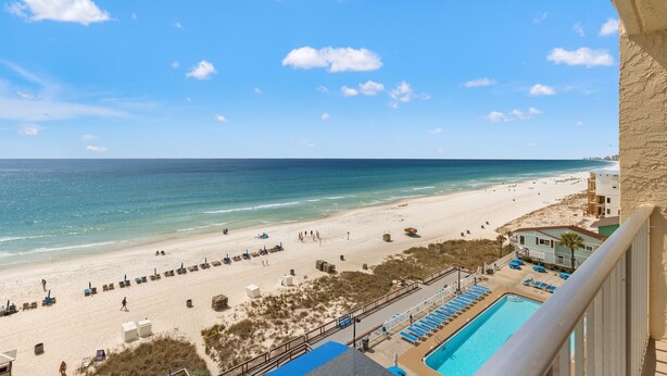 A beach view from a balcony overlooking a swimming pool and beach chairs. - 2 Bedroom Deluxe Oceanfront with 2 Large Pool Facing Beautiful Beach (Panama City)