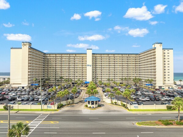 Un hotel grande con varios pisos y un estacionamiento al frente.