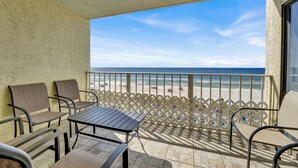 A balcony with a table and chairs, a view of the beach, and a railing. - 2bd/2ba Condo Ocean views from every room walk in shower FREE BEACH CHAIRS (Panama City Beach)