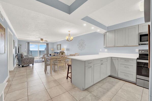 A spacious kitchen with a large island, modern appliances, and a view to the outside.