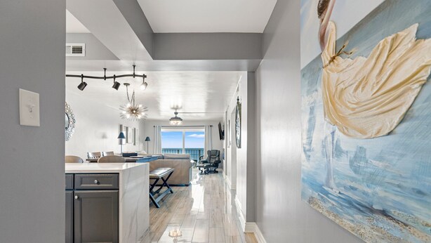 Una cocina moderna con una isla central, un comedor con vistas y un cuadro grande en la pared.