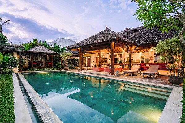 A poolside area with a covered seating area, a pool, and lush greenery. - Large 5 bedroom villa with big pool - Seminyak (Seminyak)