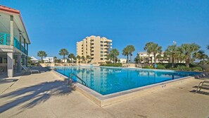 A swimming pool with lounge chairs, a building with multiple balconies, and palm trees. - 🌅Fab Sound Views-Walk2Beach-Santa Rosa Dunes 1053🌅 (Pensacola Beach)