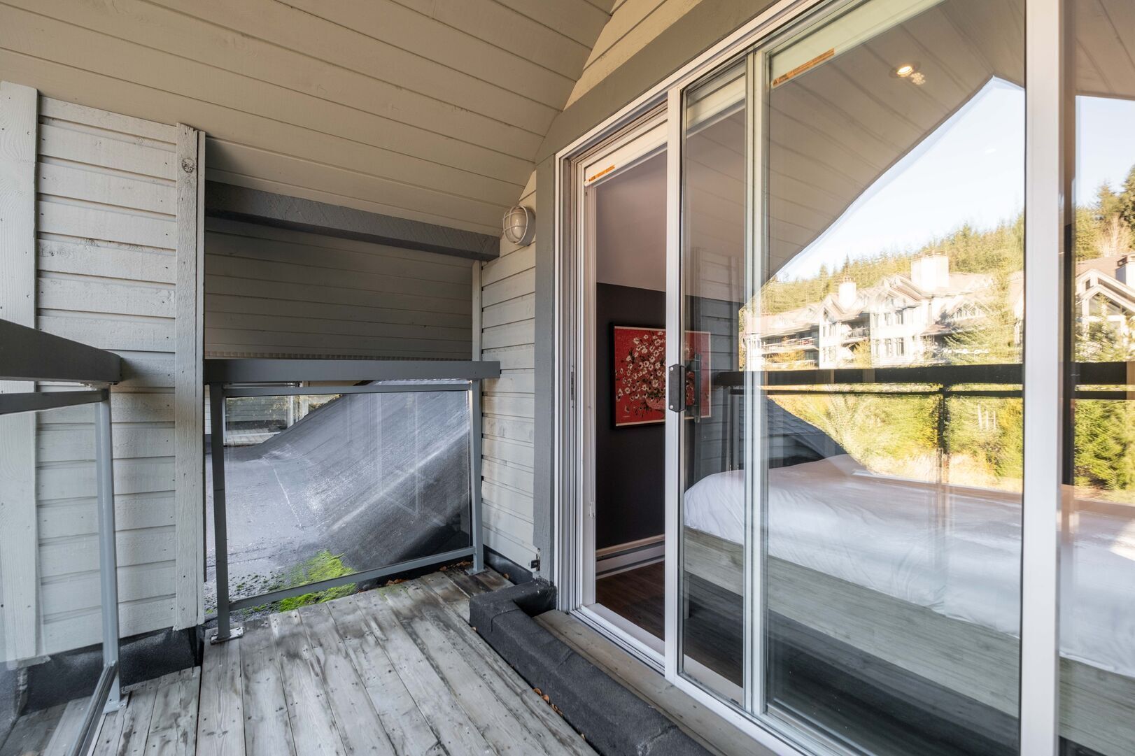 Un balcon avec une porte vitrée donnant sur une chambre.