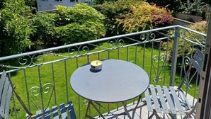 A balcony with a round table and two chairs, surrounded by a metal railing. - Stylish Family-Friendly Sea-View Home, sleeps 9 (Tenby)