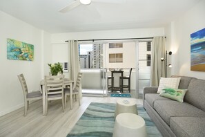 Relax in this stylish living room with a sofa, dining table, and balcony access.