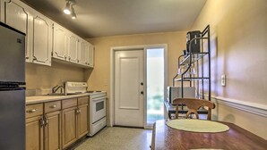 A kitchen with wooden cabinets, a refrigerator, an oven, and a dining table with chairs. - Professional 2 Bedroom Condo on Singer Island, FL.  FREE parking.  Beach 5 min. (Singer Island)