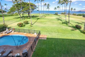 A pool area with lounge chairs and a view of the ocean. - Leinaala Oceanfront #303 Panoramic Ocean Front View, A/C Great Location, Pool (Kihei)
