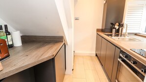 Una cucina moderna con piani di lavoro in legno, elettrodomestici in acciaio inossidabile e forno integrato.
