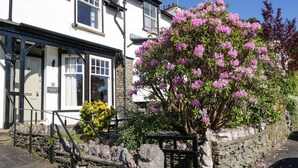 A traditional white building with a stone wall and a wooden gate. - Snowdrop Cottage (Windermere)