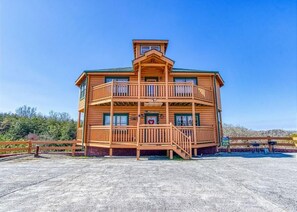 A multi-story wooden building with balconies, a central entrance, and a clear view of the surrounding landscape. - Bear Foot Lodge #308 (Sevierville)