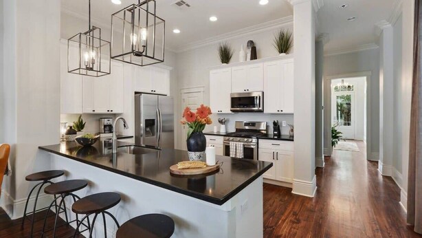 A modern kitchen with a central island, stainless steel appliances, and pendant lighting.