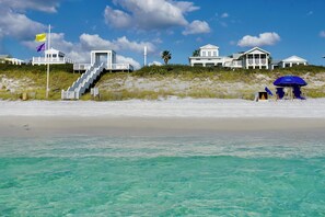 A beachfront property with a lifeguard tower, a staircase leading to a house, and a beach umbrella. - New Modern Construction With King Primary, 351 Ft. to Beach + 2 Adult Bikes! (Santa Rosa Beach)