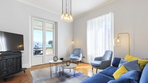 En moderne stue med en sofa, to lænestole, et sofabord og et fjernsyn.