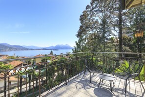 A balcony with a view of a lake and mountains, furnished with two chairs and a table. - Villa Ramella (Baveno)