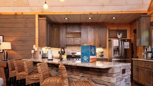 Una cucina rustica con piani in pietra, mobili in legno e un'isola integrata con sgabelli da bar.