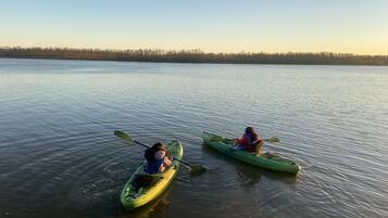 Twee kajaks op kalm water, met een bos op de achtergrond.