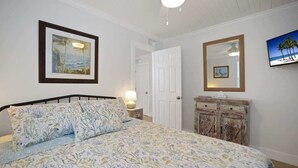 Un dormitorio con cama, cómoda, puerta y decoración en la pared.