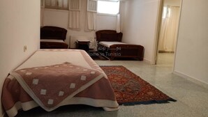 Une chambre à coucher avec un lit, un canapé, une fenêtre et une porte.