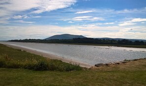 A river with a path alongside it, a grassy area, and a mountain in the background. - Belmont Cottage -  a cottage that sleeps 3 guests  in 2 bedrooms (Dumfries)