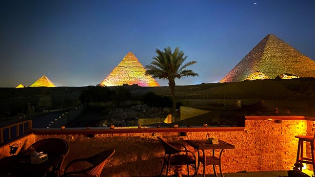 A nighttime view of the pyramids with a bar area in the foreground.