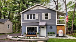 A two-story house with a front porch, a bench, and a canoe. - Wally`s House   |Kayaks|Firepit|Game Shed|Central! (Hawley)
