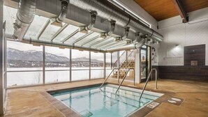 An indoor swimming pool with clear views of mountains and a snowy landscape through large windows. - Fresh Air Feelings | Indoor Pool & Hot Tub | Beach (Windermere)