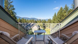 A balcony with a table and chairs, overlooking a forest and mountains. - Fresh Air Feelings | Indoor Pool & Hot Tub | Beach (Windermere)