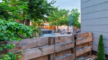 Una valla de madera con jardineras, una hamaca y mobiliario exterior en un patio trasero.