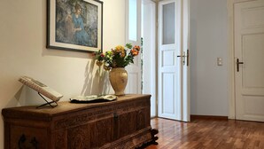 Un mueble de madera con un cuadro enmarco y un florero de flores.