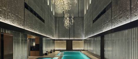 Una piscina techada, sillones reclinables de piscina