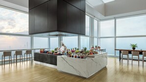 Una cocina moderna con una isla central, ventanas amplias y vistas a la ciudad.