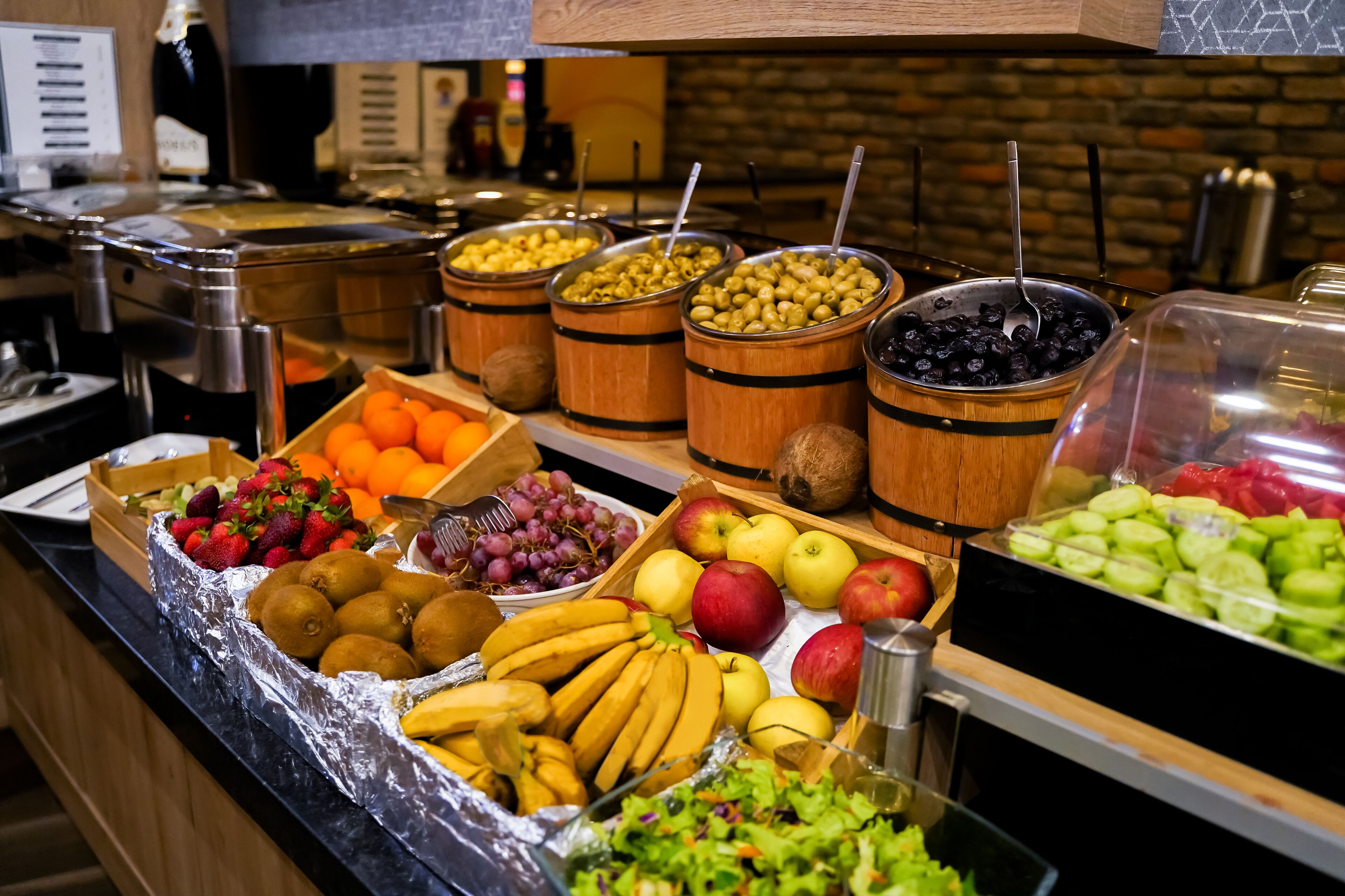 A buffet with various fruits and vegetables, including apples, bananas, oranges, and grapes.