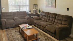 A living room with two brown sofas, a wooden coffee table, and a patterned rug. - Charming Home- 15 mins from Historic Downtown, W+D (Savannah)