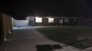 A residential house at night with a driveway leading to the entrance. - Charming Home- 15 mins from Historic Downtown, W+D (Savannah)