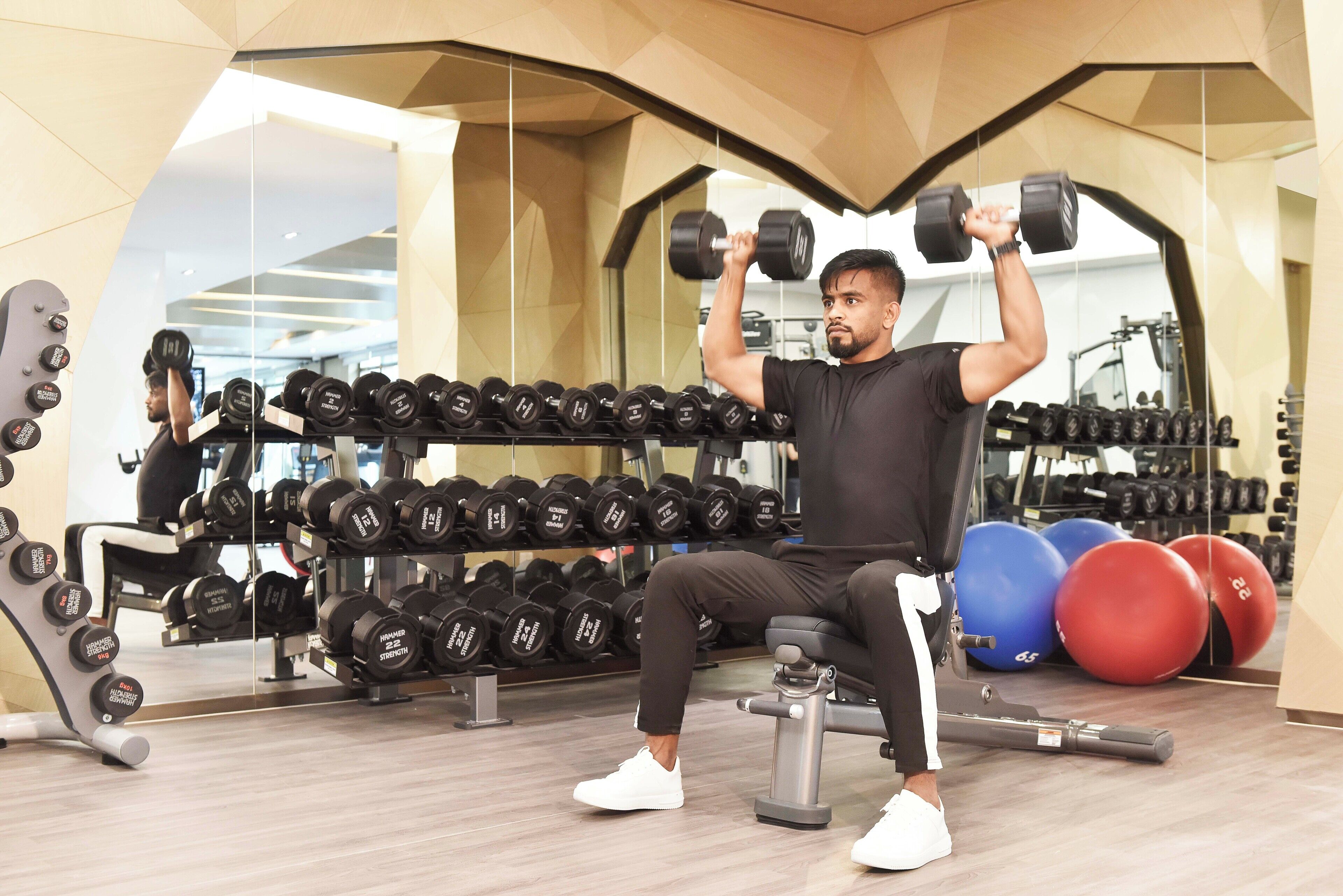 Un gimnàs amb una pica de musculació, halteres i pilotes d'exercici.