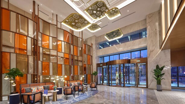 Un hall d’entrée spacieux, doté d’un espace salon, d’un sol en marbre et d’une grande entrée vitrée.