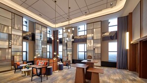 Un hall d’entrée spacieux, doté de hauts plafonds, de grandes fenêtres et de mobilier moderne.