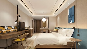 Une chambre d’hôtel moderne équipée d’un lit, d’un bureau et d’une télévision.