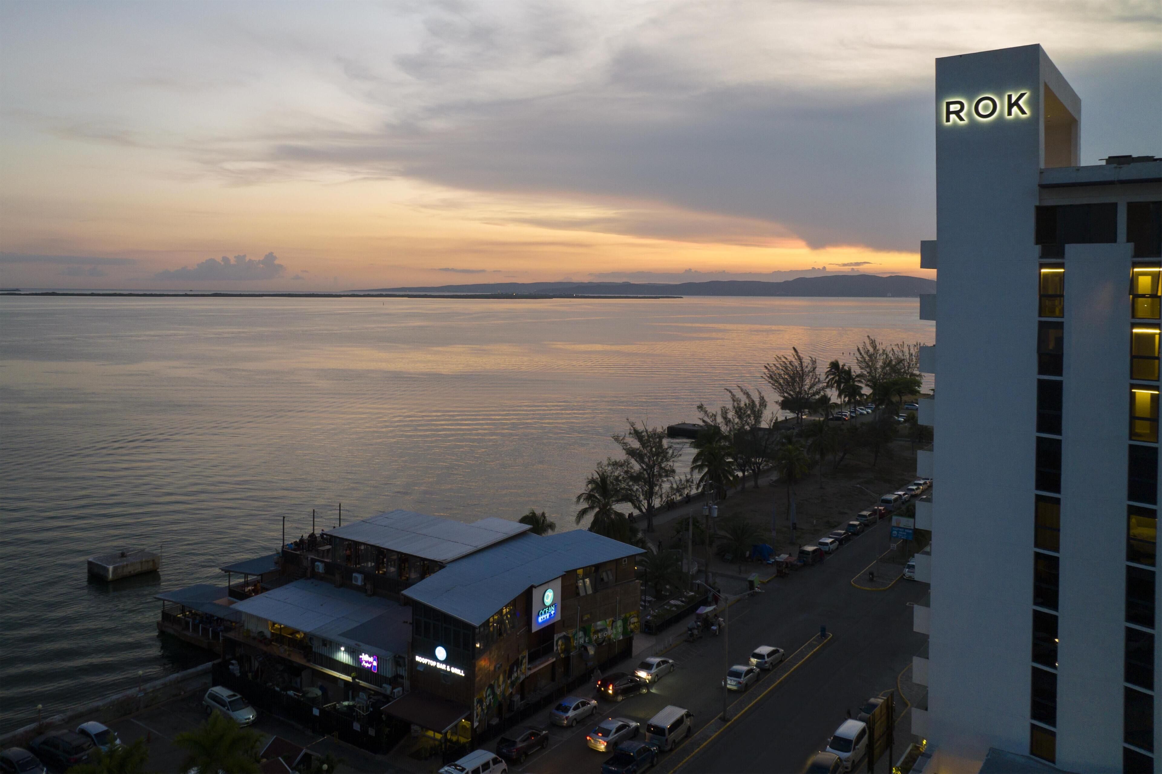 A waterfront building with a sign 'ROK' and a restaurant with outdoor seating.