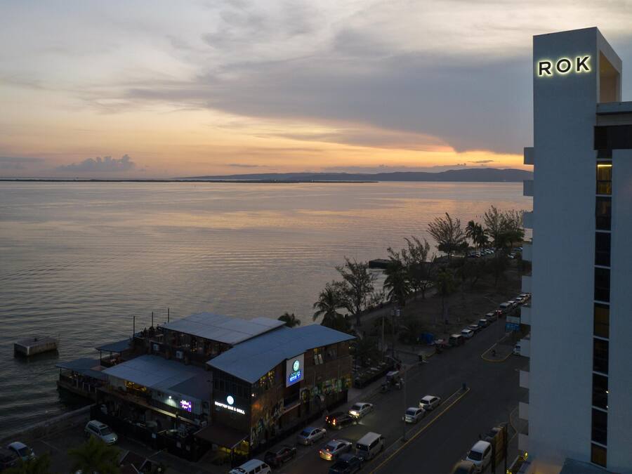 A waterfront building with a sign 'ROK' and a restaurant with outdoor seating.