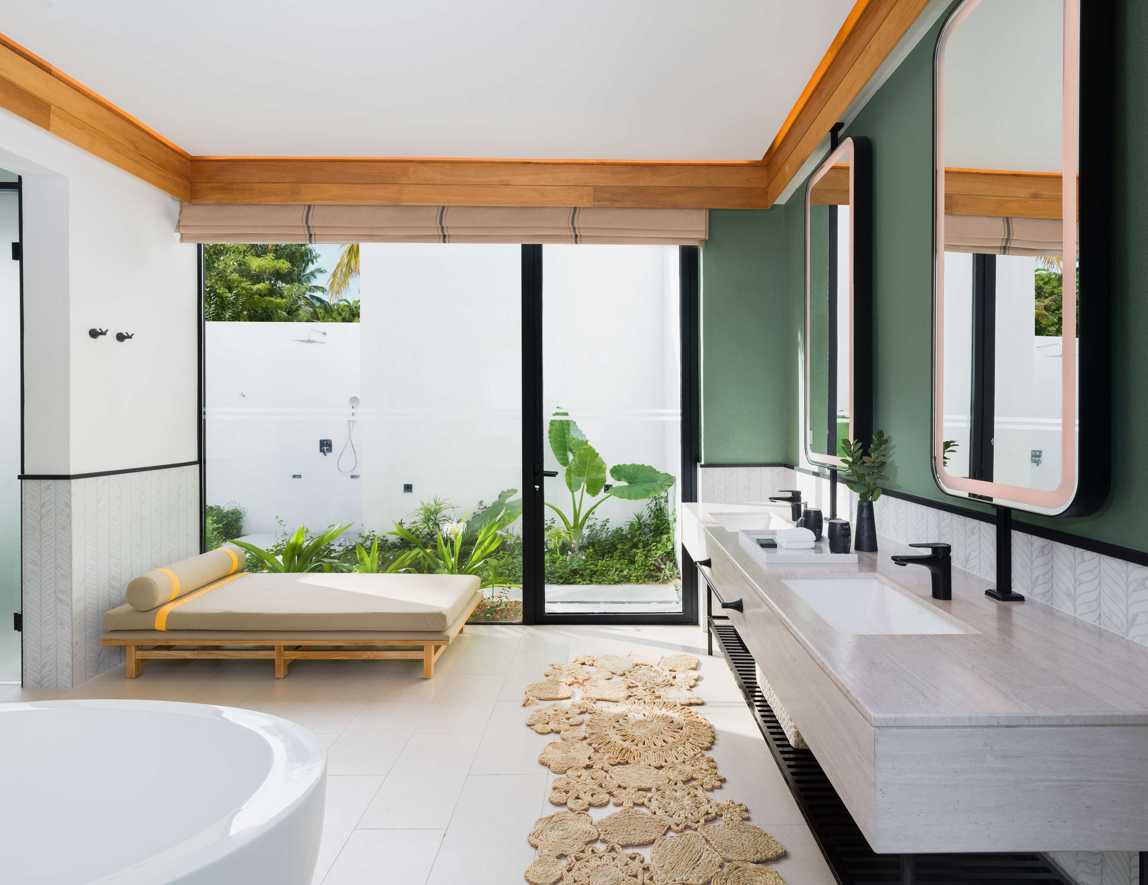 Une salle de bain moderne avec une grande baignoire, un plafond en bois et une vue sur la verdure environnante.