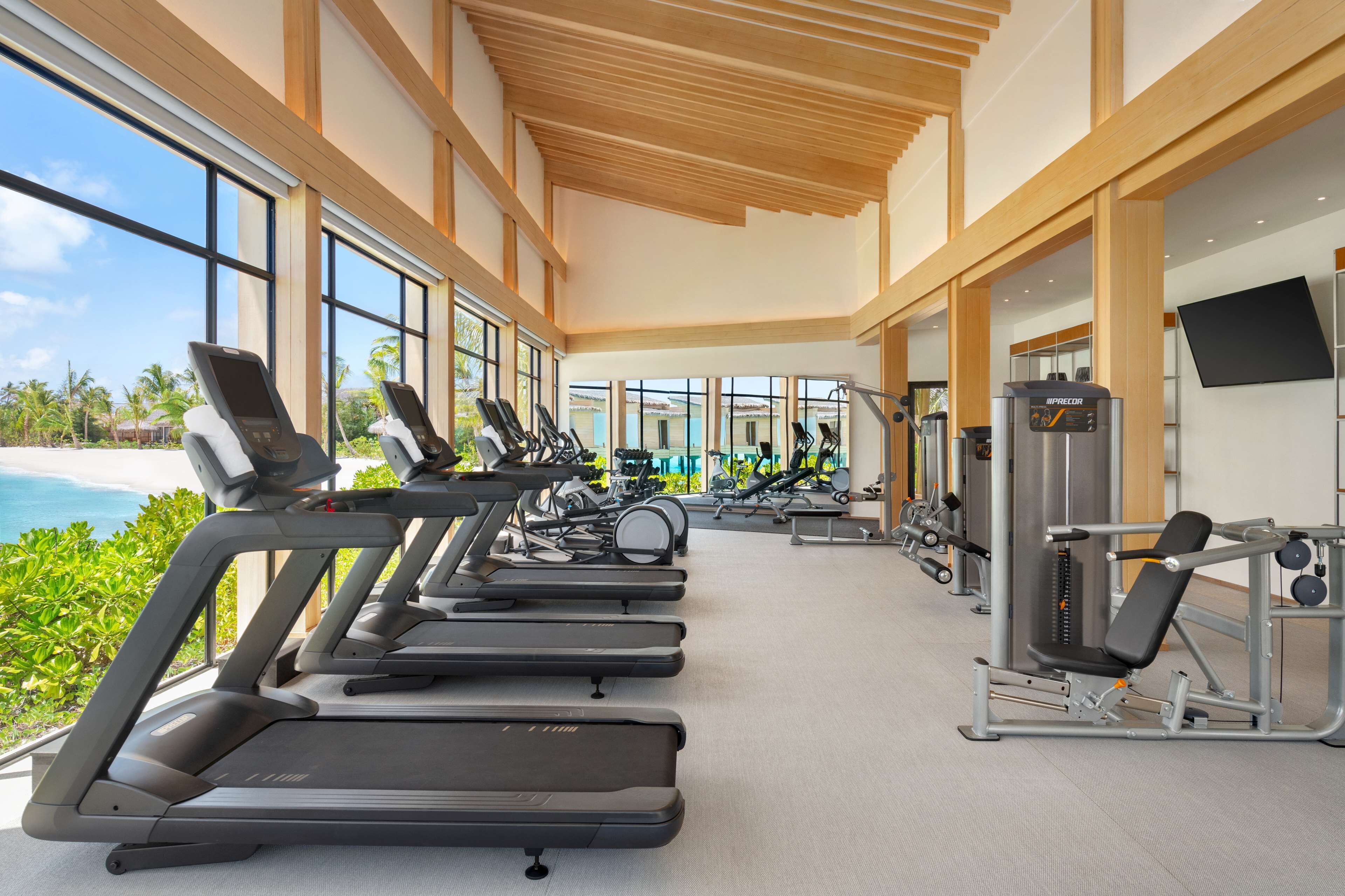 A gym with treadmills, exercise bikes, and weight machines.