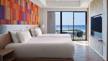 Una habitación de hotel moderna con una cama grande, un televisor y un balcón con vistas.