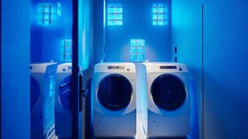 Une buanderie équipée de deux machines à laver à chargement frontal, d’une petite fenêtre et d’une porte.