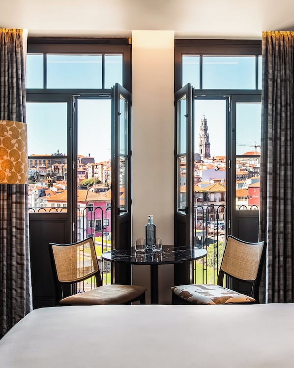 A hotel room with a balcony, two chairs, a table, and a bed. - Se Catedral Hotel Porto, Tapestry Collection By Hilton (Porto)