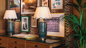 A wooden cabinet with two lamps, a leopard print wall, and framed pictures including a tiger illustration and a French phrase. - Se Catedral Hotel Porto, Tapestry Collection By Hilton (Porto)